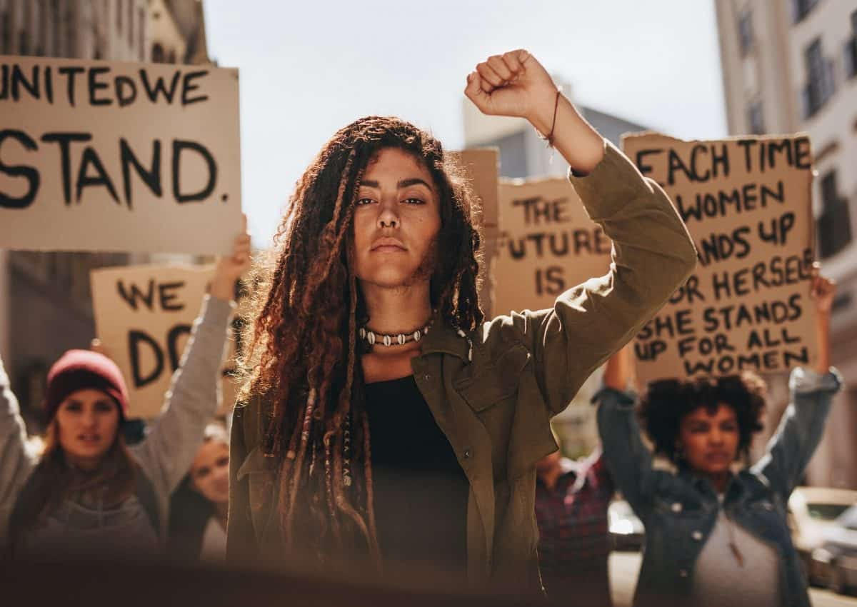 Women protesting with signs that says things like "United We Stand"